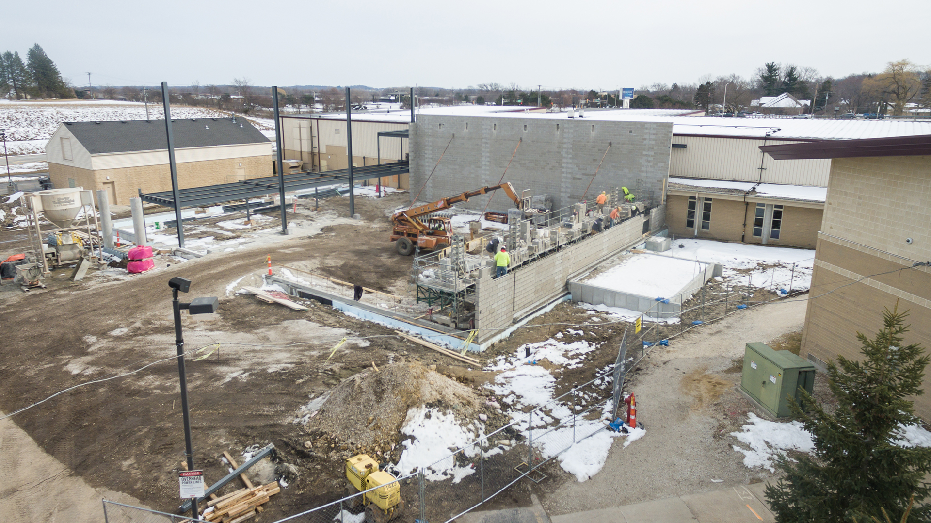 This aerial view shows you the entire job site, and in it you can see the masons working on the 2nd of 4 structural block walls, and you can see the steel associated with the lobby.