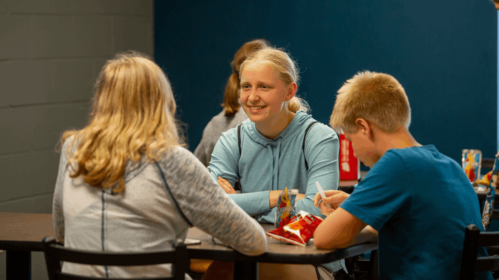 Three students enjoy their time in a cafe.