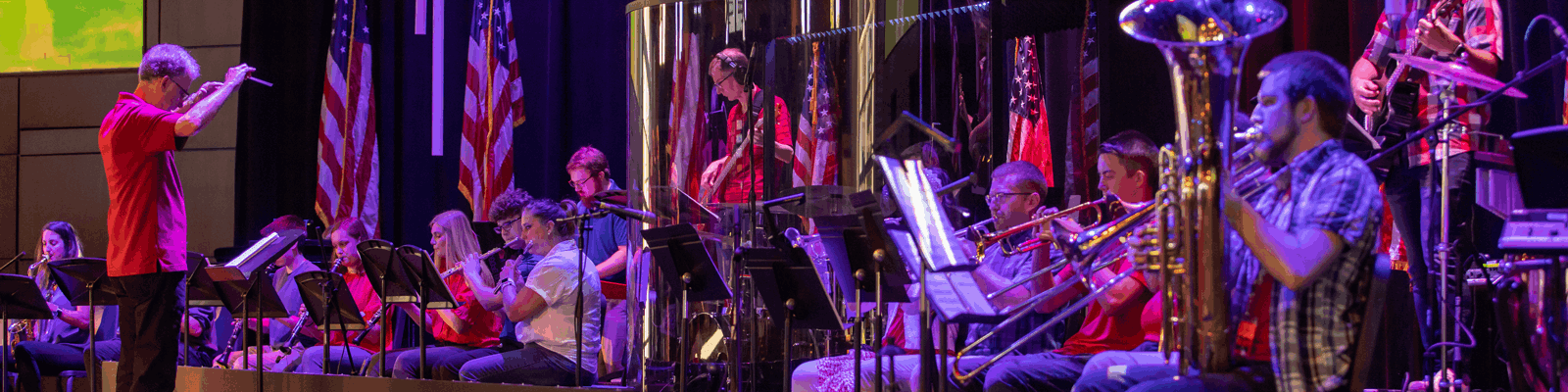 A band director conducts an orchestra for a church event.